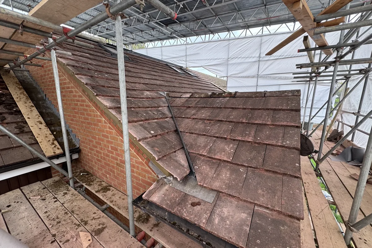 Clay plain tiles laid on a new extension roof with a roof window